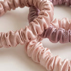 Detalle macro de dos coleteros de seda rosa palo y malva: fruncido y brillo