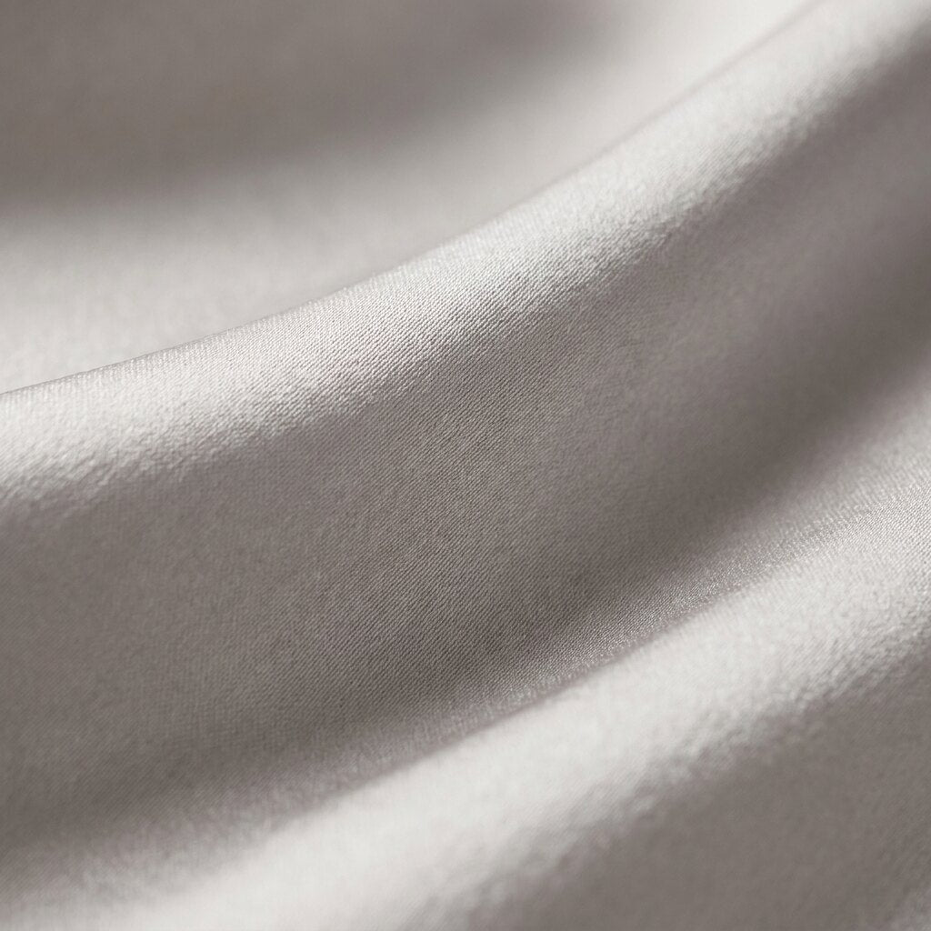 Detalle macro de la seda de morera gris perla: pliegues y brillo satinado